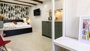A modern bedroom with a bed, bedside table, and a TV mounted on the wall. - La Stanza del Principe (Naples)