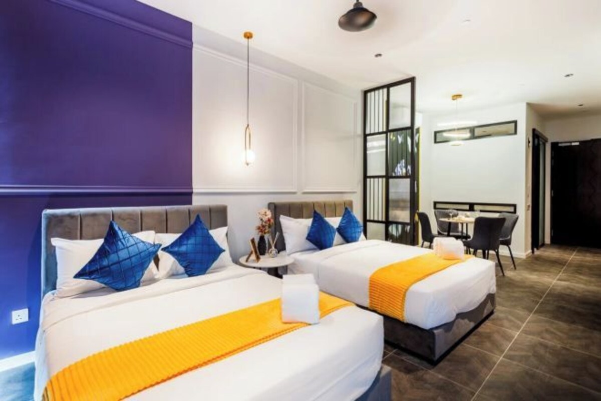 Hotellihuone, jossa on kaksi sänkyä, ruokailutila ja näkymä kaupunkiin.