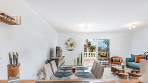 A modern living room with a dining area, a sofa set, and a view of the outdoors. - Casa Orquidea 4 (Adeje Miraverde)