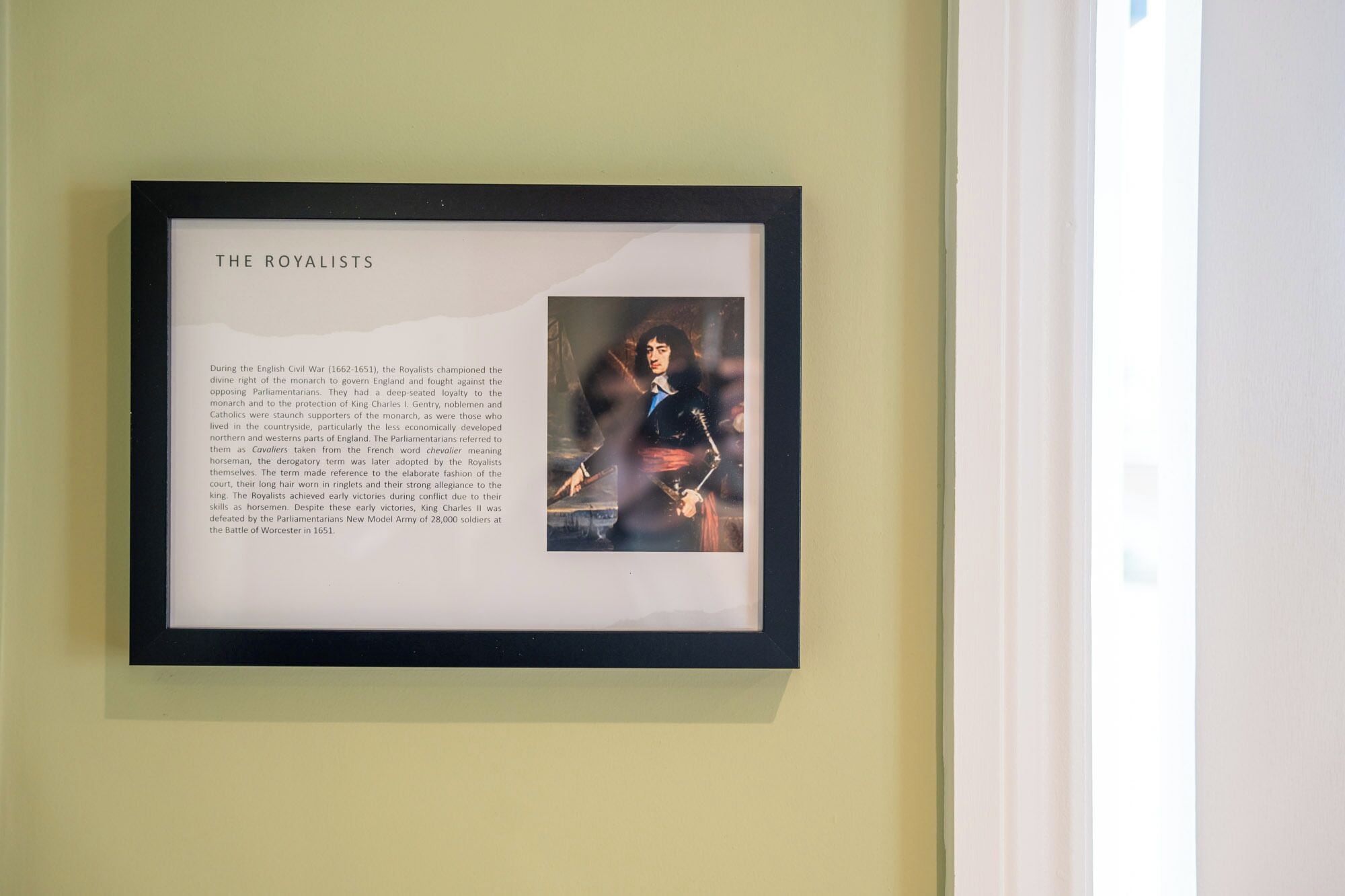 A framed informational display titled "THE ROYALISTS" with text and a historical painting.