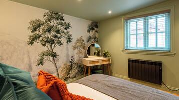 Un dormitorio con cama, cómoda con espejo, radiador y ventana con persianas.