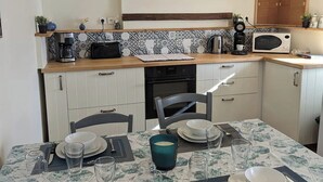Una cocina limpia y moderna con armarios blancos, microondas y cafetera.
