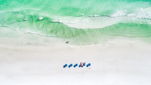 A beach with clear turquoise water and white sand.