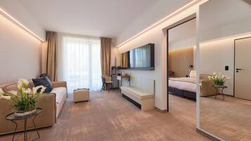 Una habitación de hotel moderna con sofá, escritorio, cama y un espejo grande.