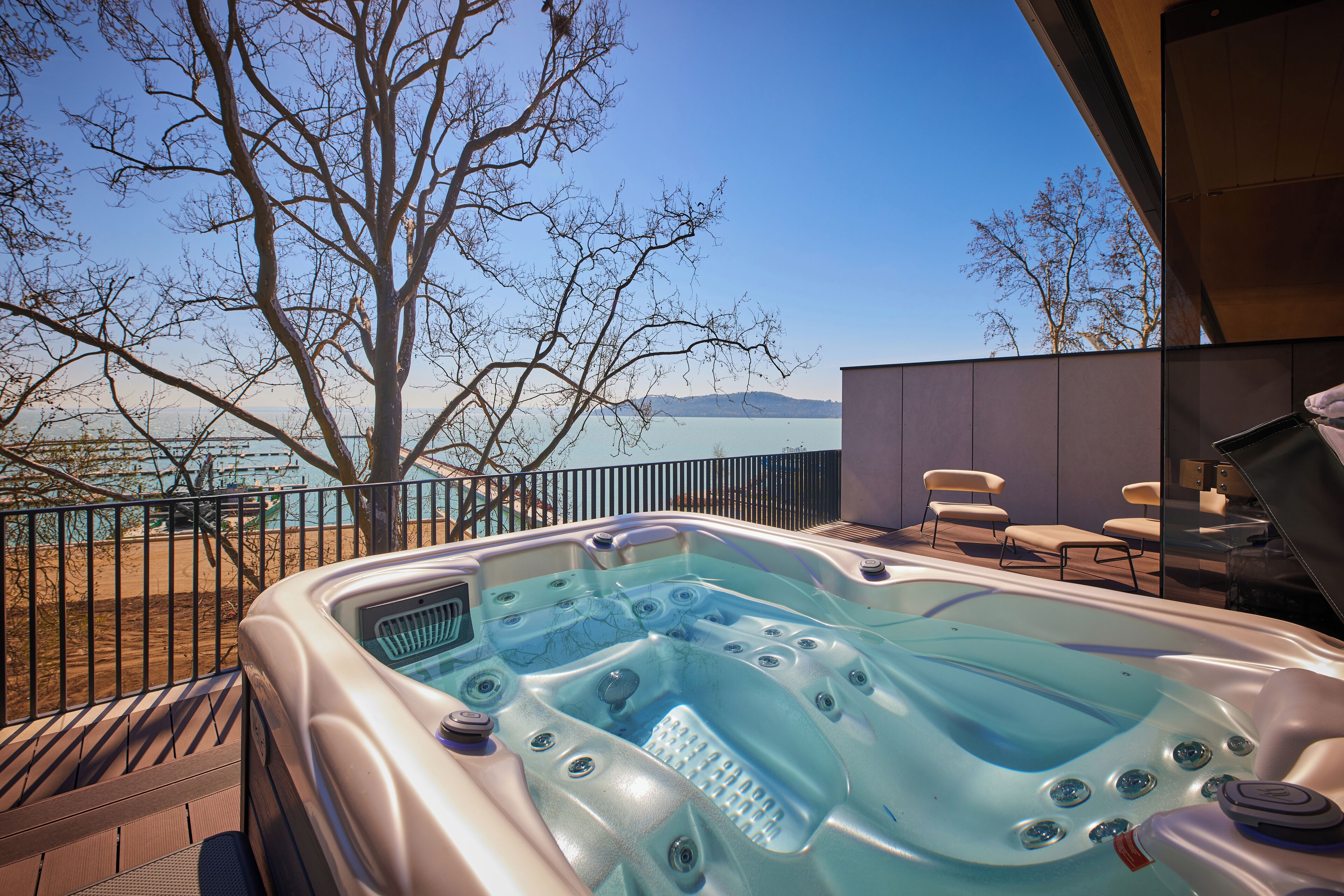 A hot tub with a clear view of the lake and mountains in the background.