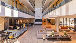 A spacious lobby with a central seating area, a bar, and a reception desk. - LUA Resort Balatonfüred (Balatonfured)