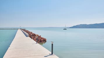 Un muelle de concreto se adentra en aguas tranquilas bajo un cielo despejado.