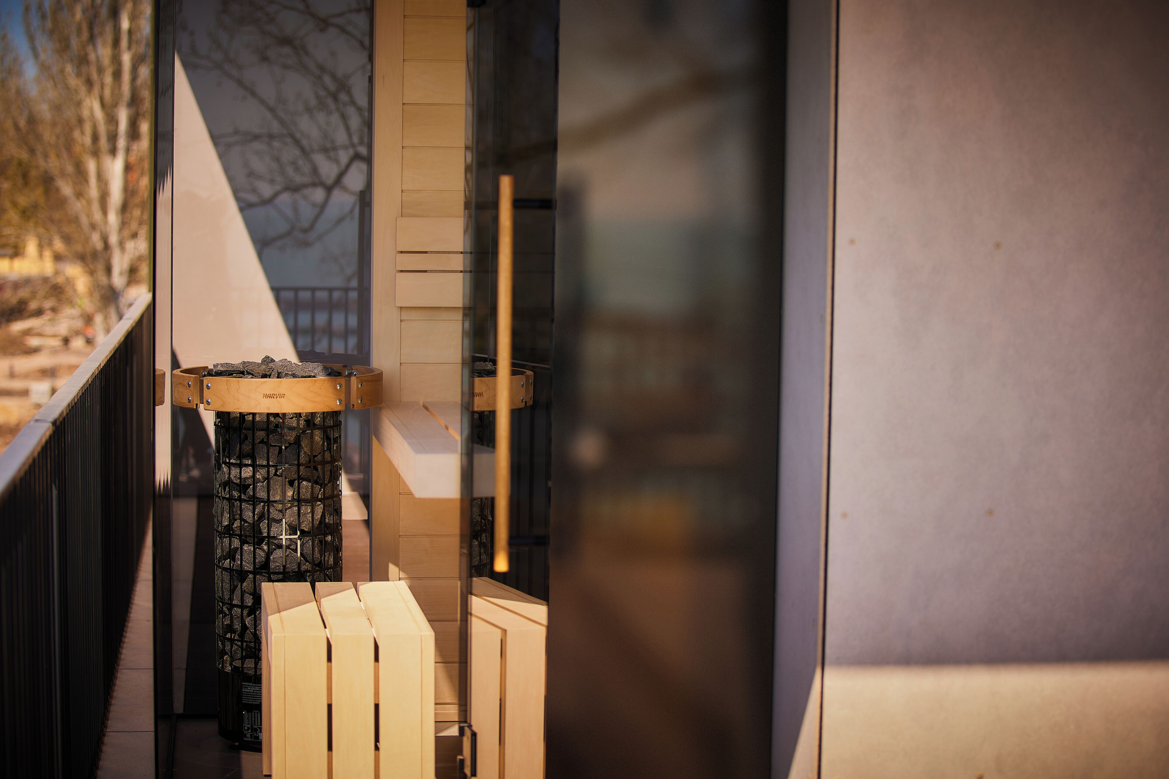 A narrow corridor with a stone pillar, wooden boxes, and a metal railing.