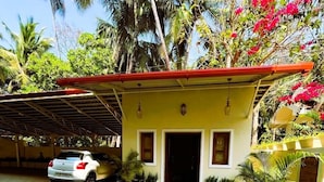 A two-story house with a tiled driveway, a parked car, and a covered porch. - Hotel Jagat inn (Haridwar)