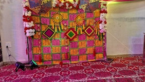 A decorated stage with colorful patterns and floral arrangements. - Hotel Jagat inn (Haridwar)
