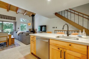 A modern kitchen with a built-in dishwasher, wooden cabinets, and a stainless steel sink.