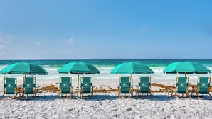 A row of beach chairs and umbrellas on a sandy beach with the ocean in the background. - Oceanfront Destin Condo With Pool & Beach Access (Destin)
