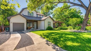 A two-story house with a garage, a covered porch, and a well-maintained lawn. - Spacious Austin Home: Near S Congress & Downtown! (Austin)