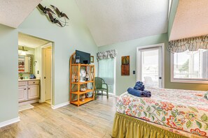 A bedroom with a bed, a wooden chair, a TV, and a bookshelf. - Myrtle Beach Condo Near Ocean: 1 Mi to Apache Pier (Myrtle Beach)