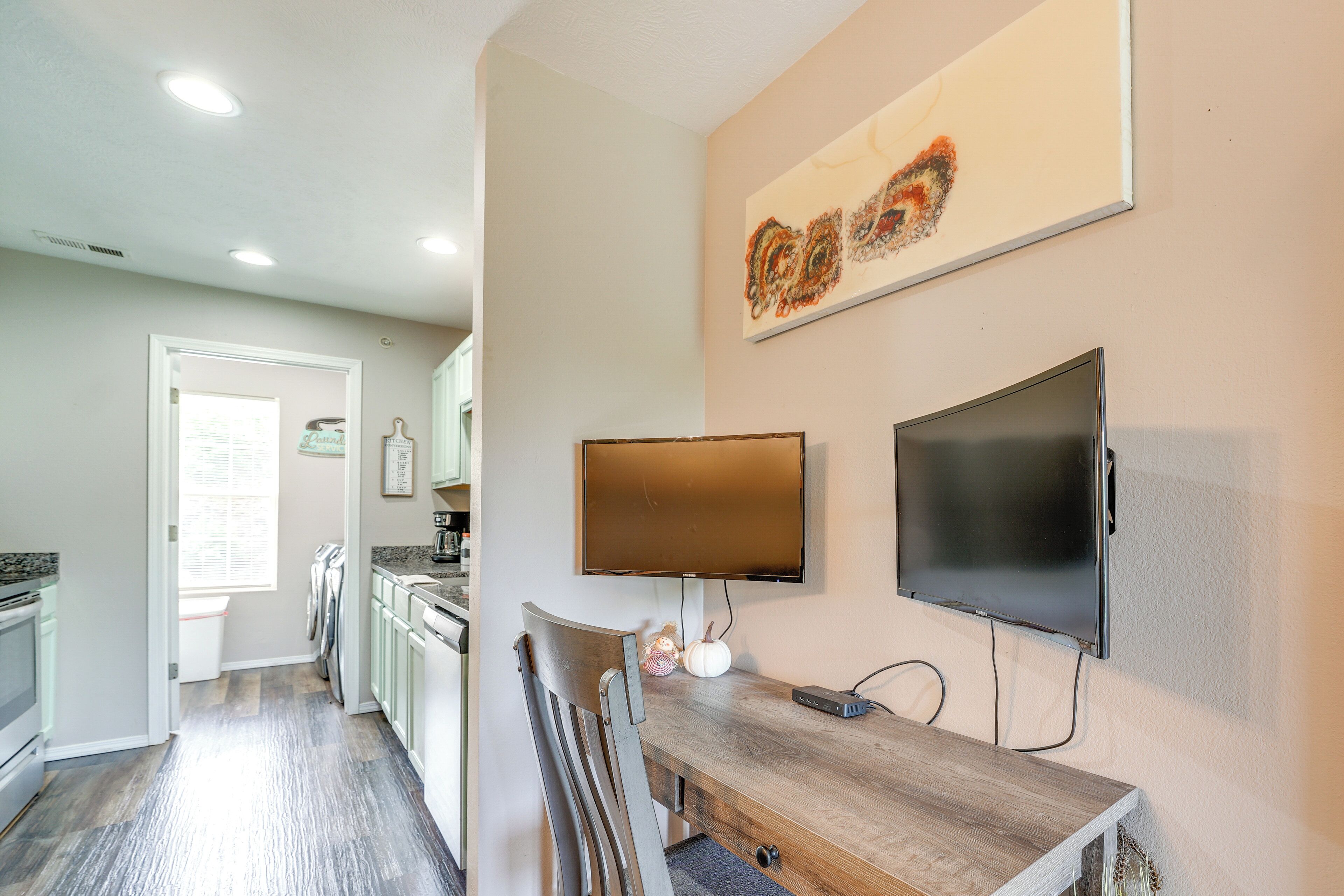 Una cocina moderna con comedor, televisor de pantalla plana y un elemento decorativo en la pared.