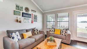 A living room with two sofas, a coffee table, and decorative wall art. - Private Dock & Deck: Eagle Mountain Lake Retreat! (Newark)