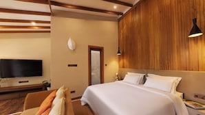 A hotel room with a large bed, a flat-screen TV, a wooden accent wall, and a modern lamp. - Ara by Colombo Villas  (Colombo)