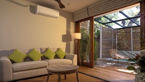 A living room with a sofa, a round wooden table, and a ceiling fan. - Ara by Colombo Villas  (Colombo)