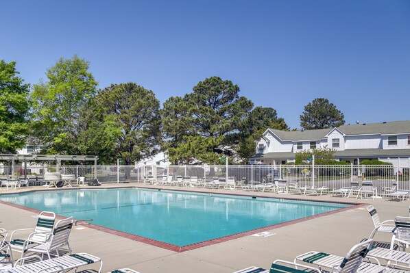 A swimming pool with lounge chairs and a fenced area, surrounded by trees and a building. - 2 Mi to Beach: Gem w/ Enclosed Patio in Selbyville (Selbyville)