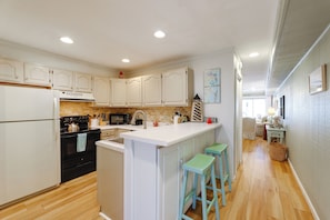 A kitchen with white cabinets, a central island, and wooden flooring. - 2 Mi to Beach: Gem w/ Enclosed Patio in Selbyville (Selbyville)