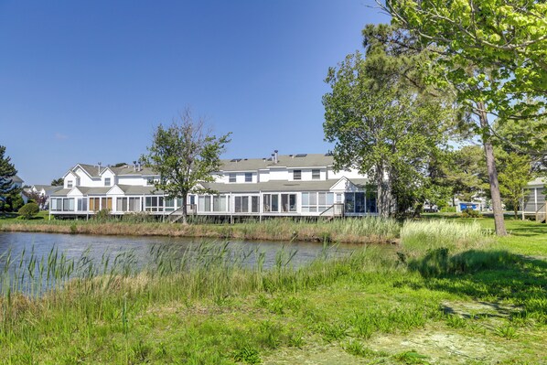 A waterfront property with a row of houses, a grassy area, and a body of water. - 2 Mi to Beach: Gem w/ Enclosed Patio in Selbyville (Selbyville)