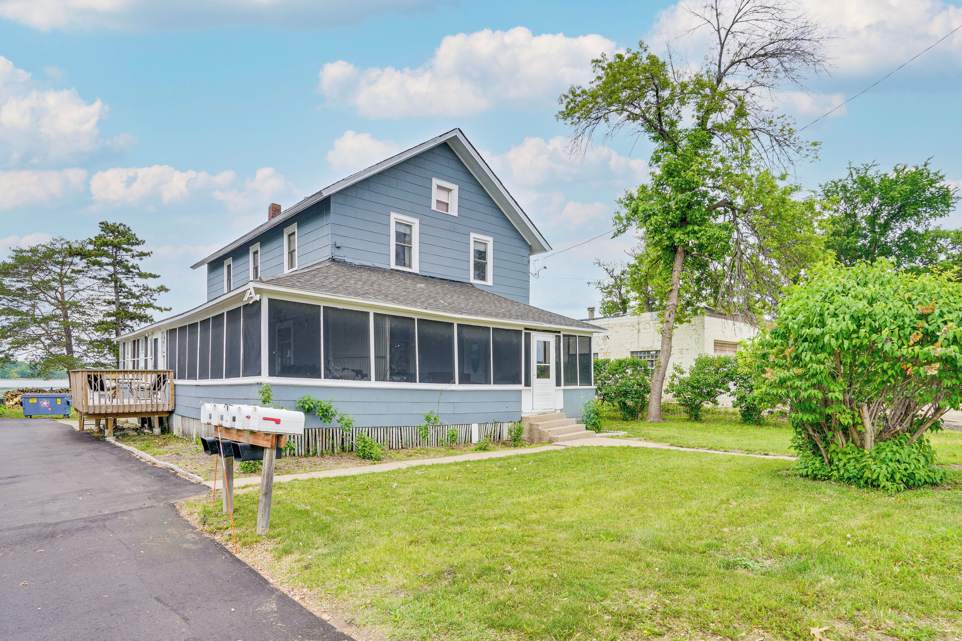 A two-story house with a large porch and a covered front porch area.