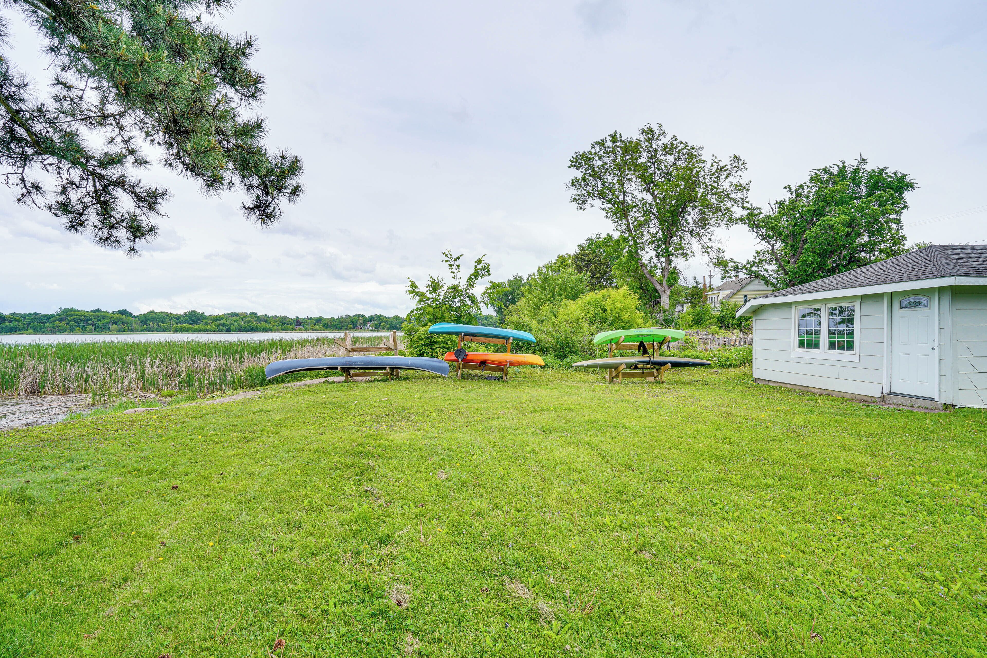 A grassy area with several canoes and a small building.
