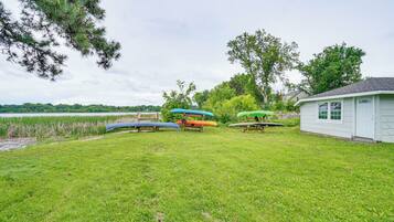 A grassy area with several canoes and a small building.