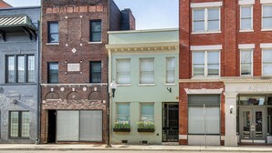 A row of multi-story buildings with various architectural styles, including brick facades and large windows. - Loft in the Heart of Dtwn Knoxville (Knoxville)