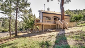 A two-story building with a wooden deck and stairs leading to the entrance. - Pine Mountain Club Cabin w/ A/C & EV Charger (Pine Mountain Club)