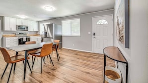 A modern kitchen with white cabinets, a dining table with chairs, and a built-in oven. - Updated Yakima Vacation Rental: Central Location! (Yakima)