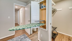 A compact room with a built-in ironing station, a small seating area, and a visible door leading to another room. - Updated Yakima Vacation Rental: Central Location! (Yakima)