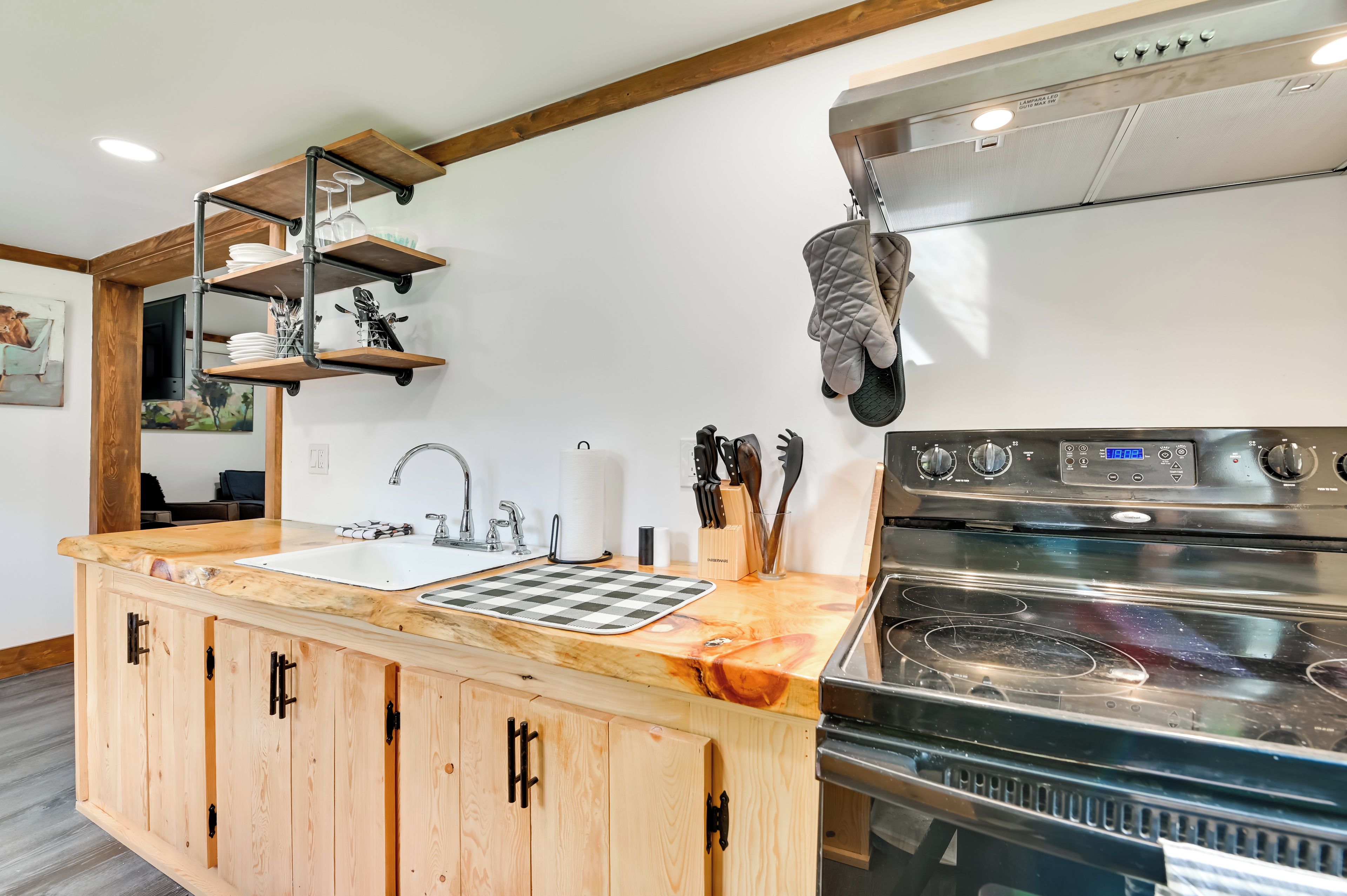 Una cucina con piano di lavoro in legno, elettrodomestici in acciaio inossidabile e porta pentole pensile.