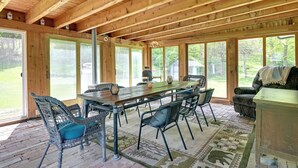 A wooden dining area with a large table and chairs, large windows, and a view of the outdoors. - Catskills Family Retreat: Fishing & Hiking On-site (East Durham)