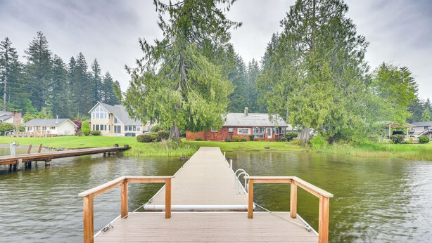 A wooden dock leading to a calm lake with houses and trees in the background. - Waterfront Grapeview Escape w/ Boat Dock & Views! (Grapeview)