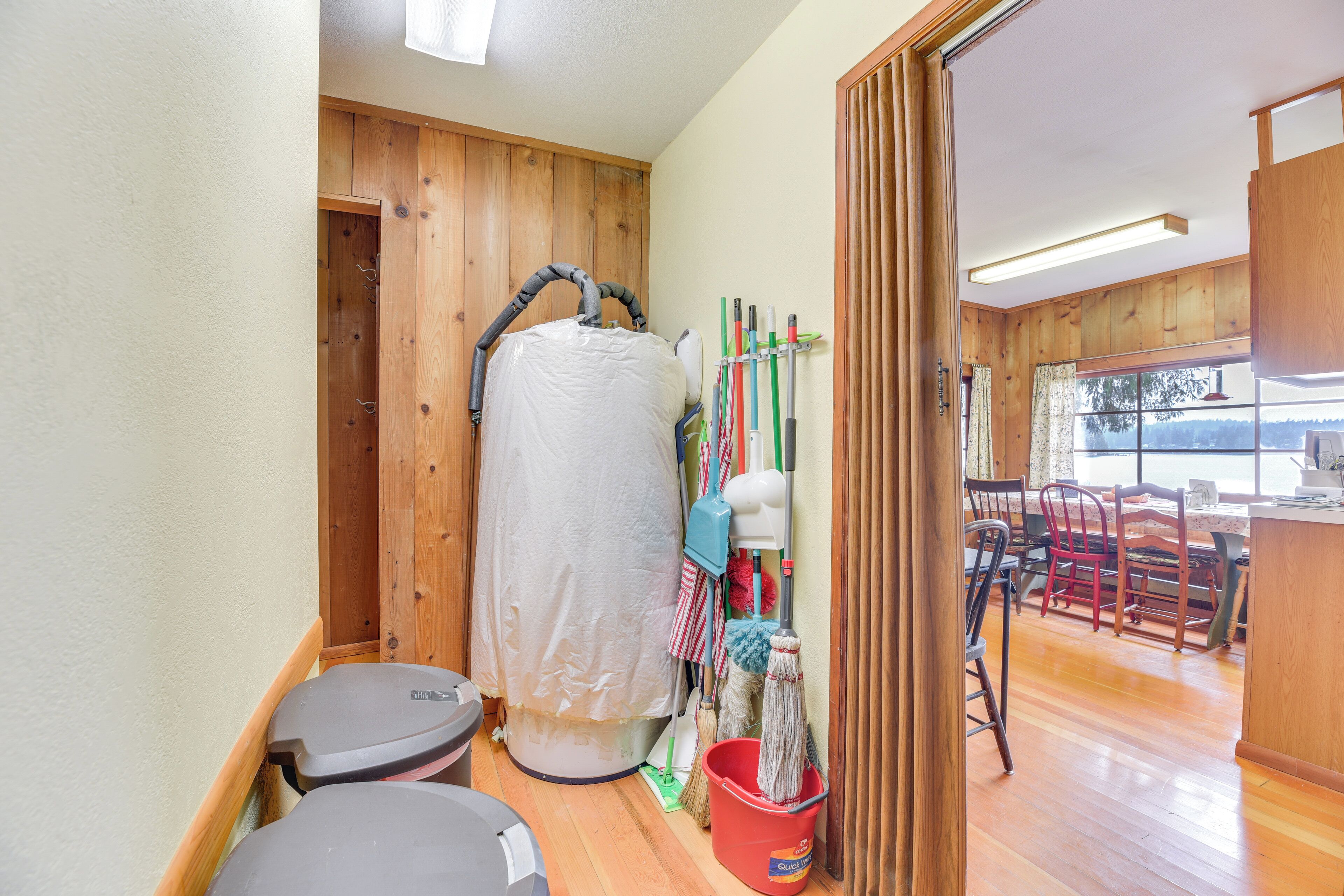 A bathroom with a wooden floor, a shower area, and a toilet.