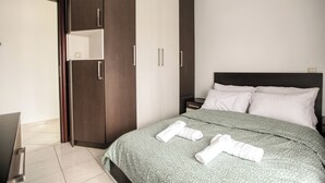 A hotel room with a bed, a wardrobe, and a nightstand. - Meteora's Secret Garden House 2 (Kalabaka)