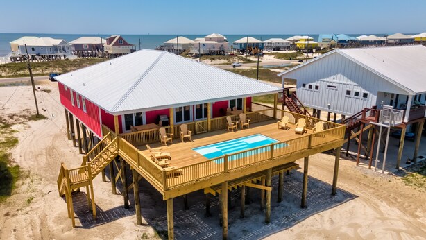 Ein Strandhaus mit Pool, Terrasse und mehreren Zimmern.