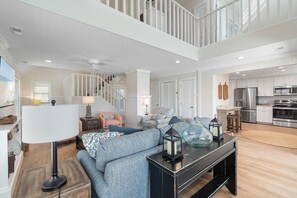A spacious living area with a staircase, a kitchen, and a dining area. - Anster / 144 Tuna Drive 3 Bedroom Home by RedAwning (Supply)
