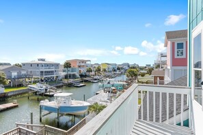 Un port de plaisance avec des bateaux amarrés, une vue sur le front de mer et des immeubles résidentiels dotés de balcons.