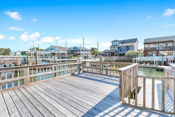 A wooden pier with a view of waterfront buildings and boats.
