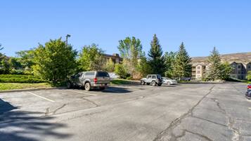 A parking lot with several vehicles, including SUVs and a compact car.