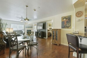 A spacious living area with a dining table, chairs, a sofa, and a television. - River Pines C207 2 Bedroom Condo by RedAwning (Edwards)