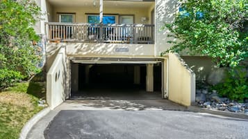 A building with a garage entrance, a balcony, and a sign indicating 'LOW CLEARANCE 6'8'.