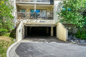 A building with a garage entrance, a balcony, and a sign indicating 'LOW CLEARANCE 6'8'.