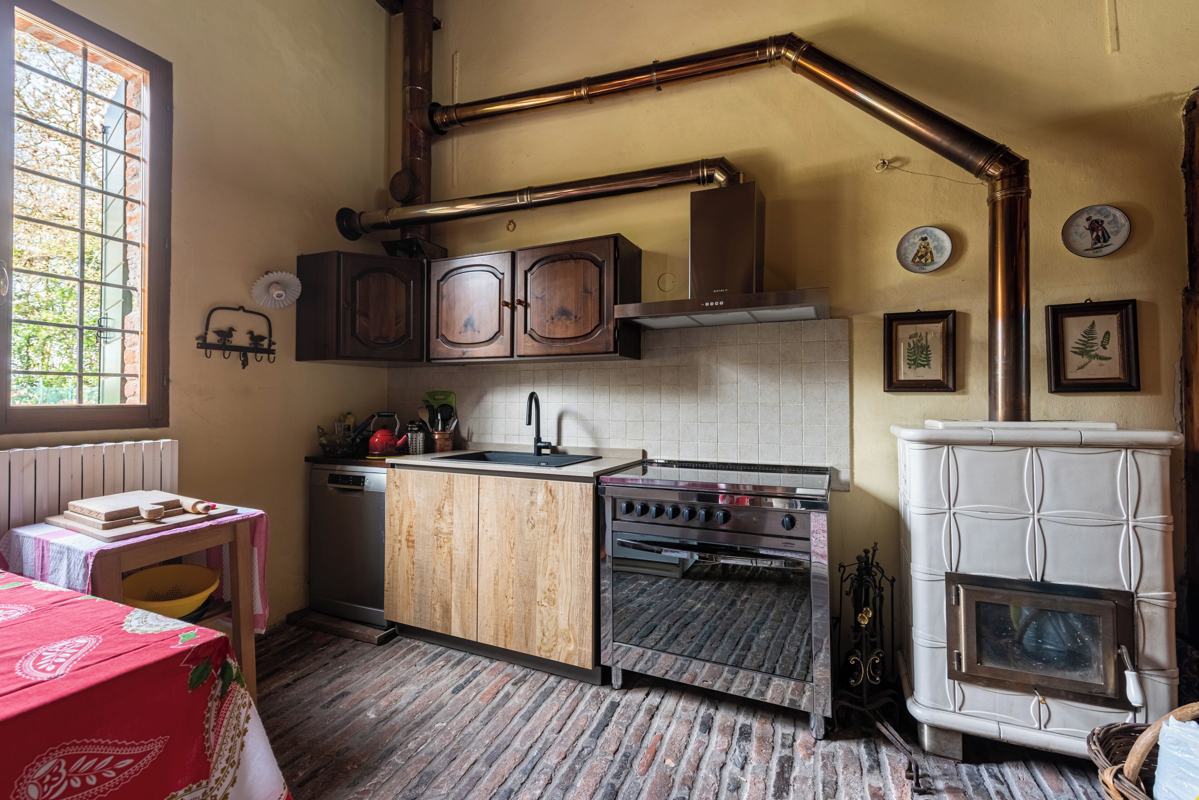 Eine Küche mit Holzschränken, einem Herd und einem weißen Kühlschrank.