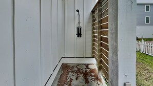 A narrow, enclosed porch with a wooden ceiling and a white door. - Shore Sounds Fun | Beach Views + Pet Friendly! (Surf City)