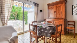 A dining area with a table set for four, wooden chairs, and a cabinet.