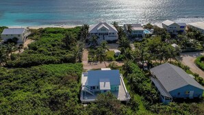 Ein Küstenresort mit mehreren Gebäuden, einem Strand und üppiger Vegetation.