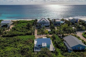 Ein Küstenresort mit mehreren Gebäuden, einem Strand und üppiger Vegetation.